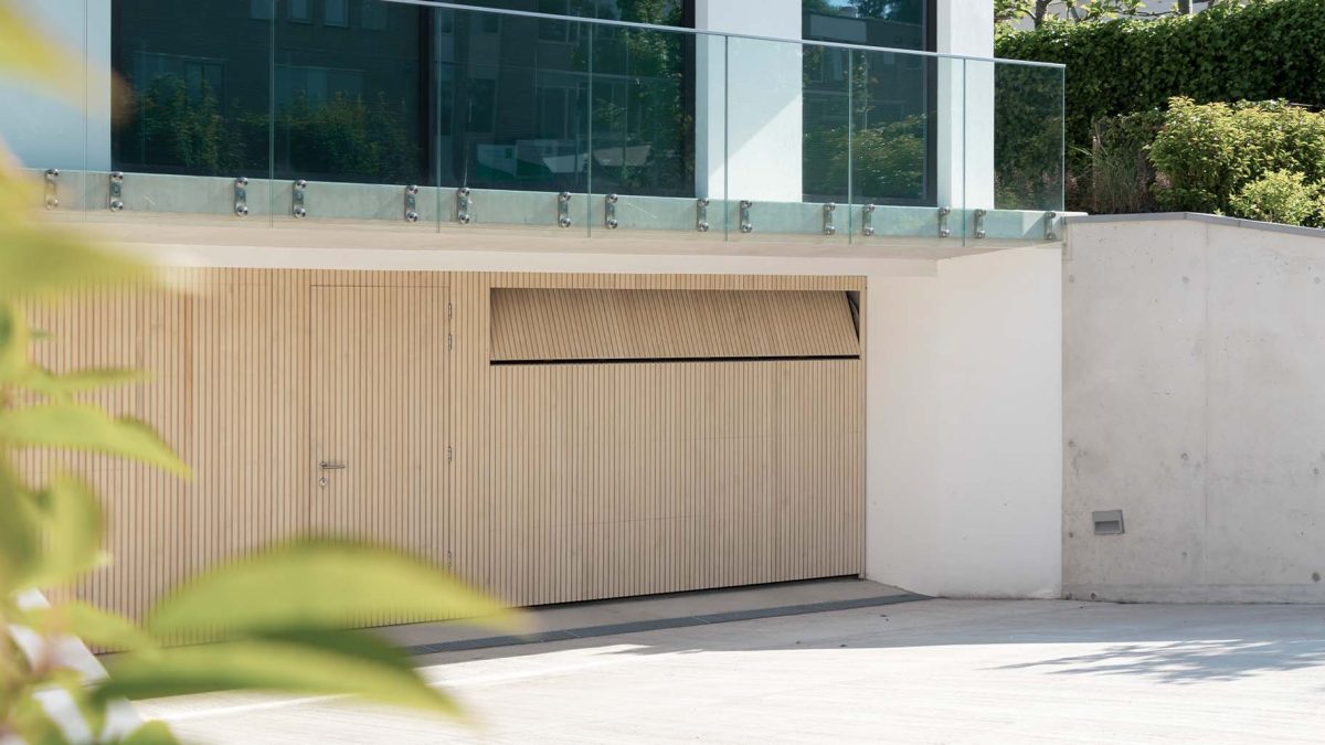Garage met op maat gemaakte Accoya houten sectionaaldeuren en geïntegreerde loopdeu