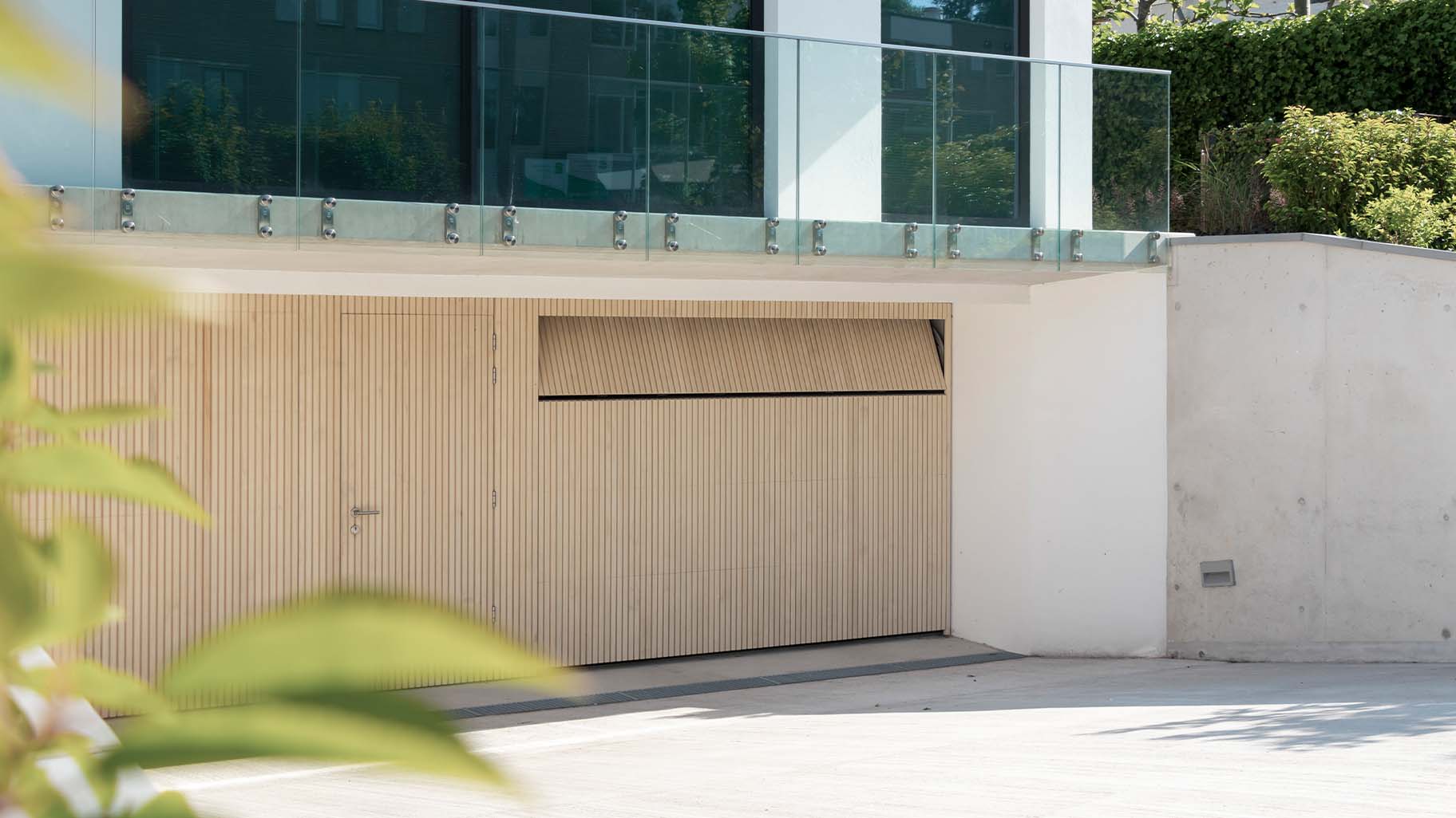 Houten sectionaaldeuren met loopdeur van Accoya hout gemaakt door Different Doors