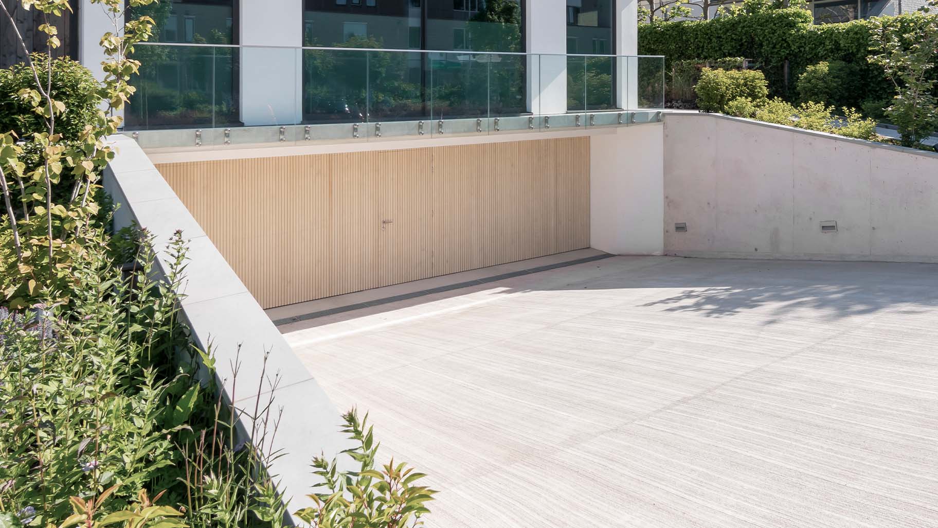 Garage met op maat gemaakte Accoya houten sectionaaldeuren en geïntegreerde loopdeu