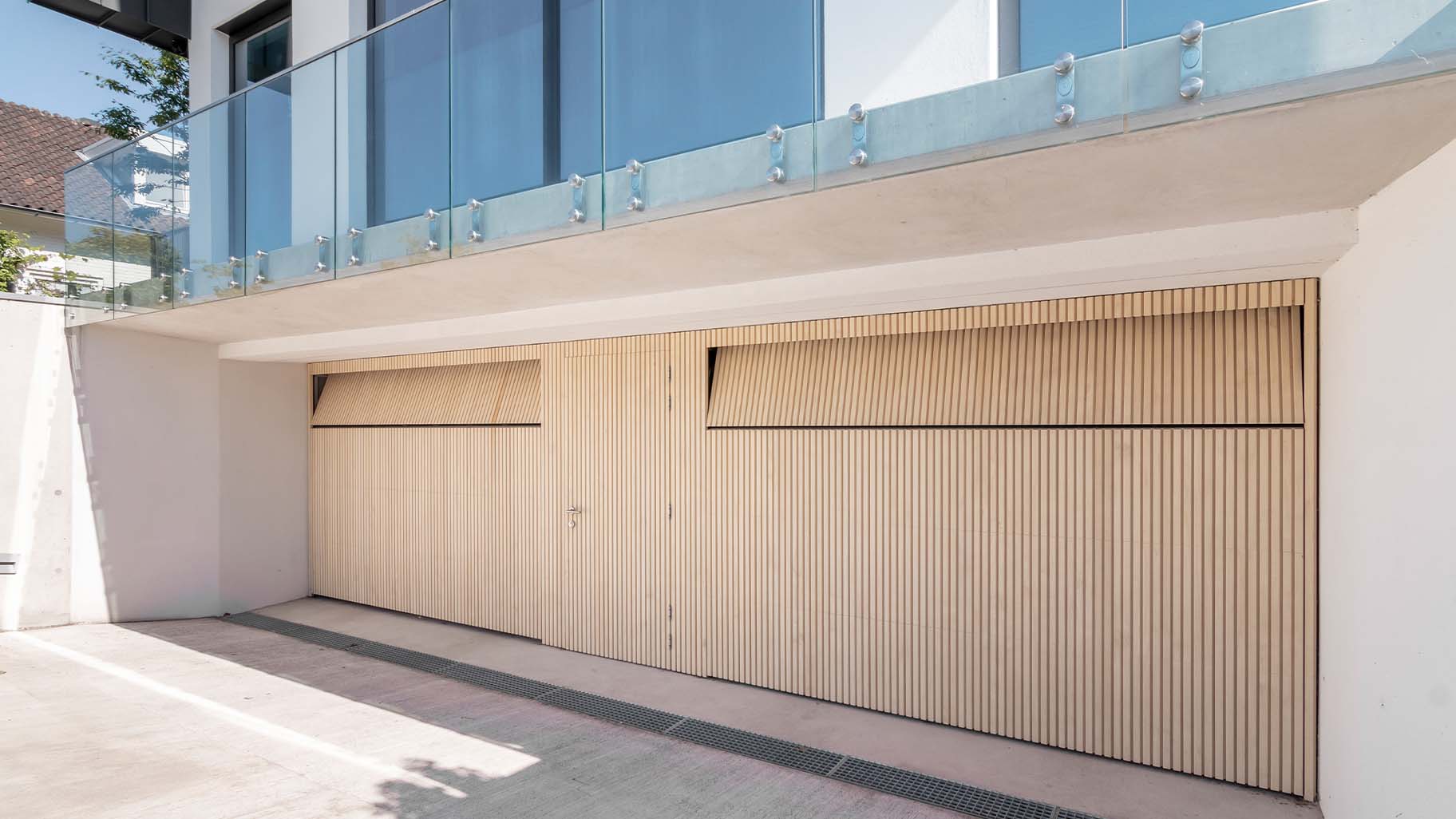 Garage met op maat gemaakte Accoya houten sectionaaldeuren en geïntegreerde loopdeu