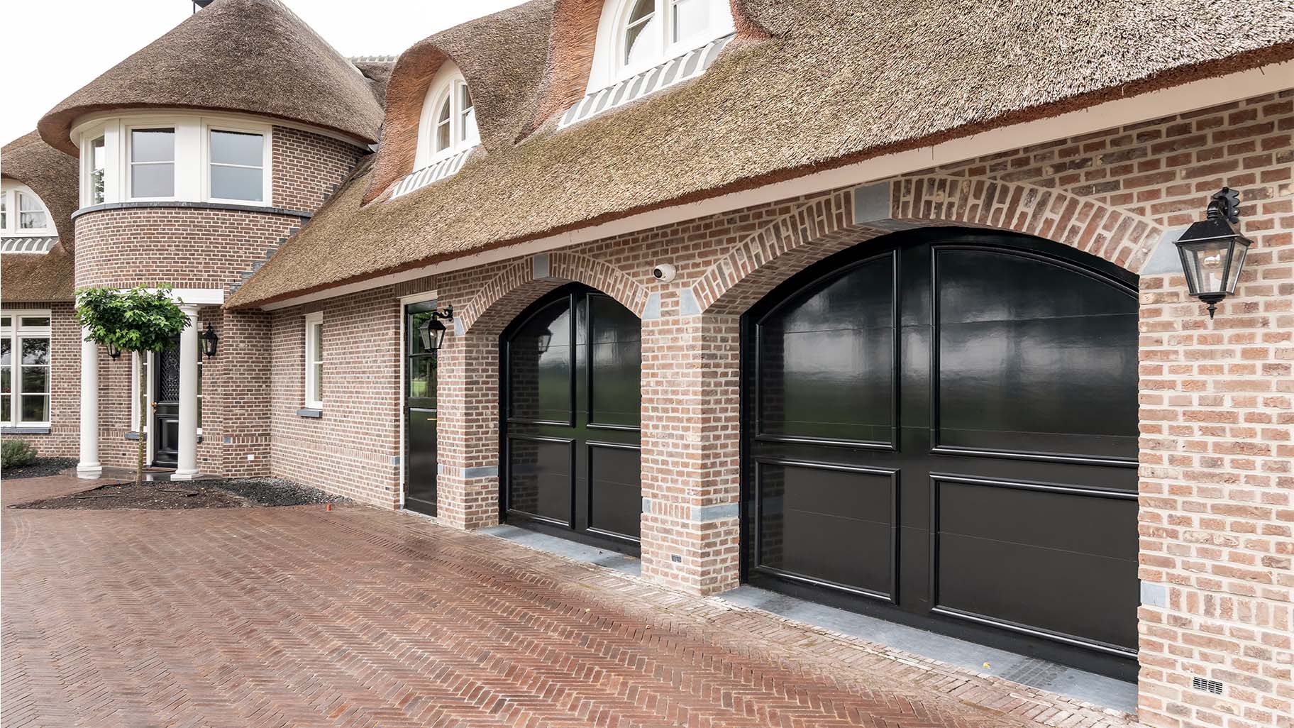 Landelijke woning met twee houten garagedeuren in klassieke stijl