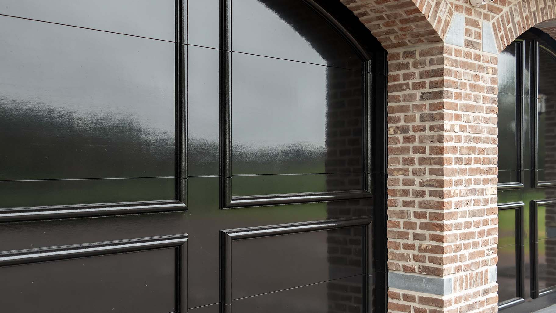 Detail van een houten garagedeur met een klassiek ontwerp