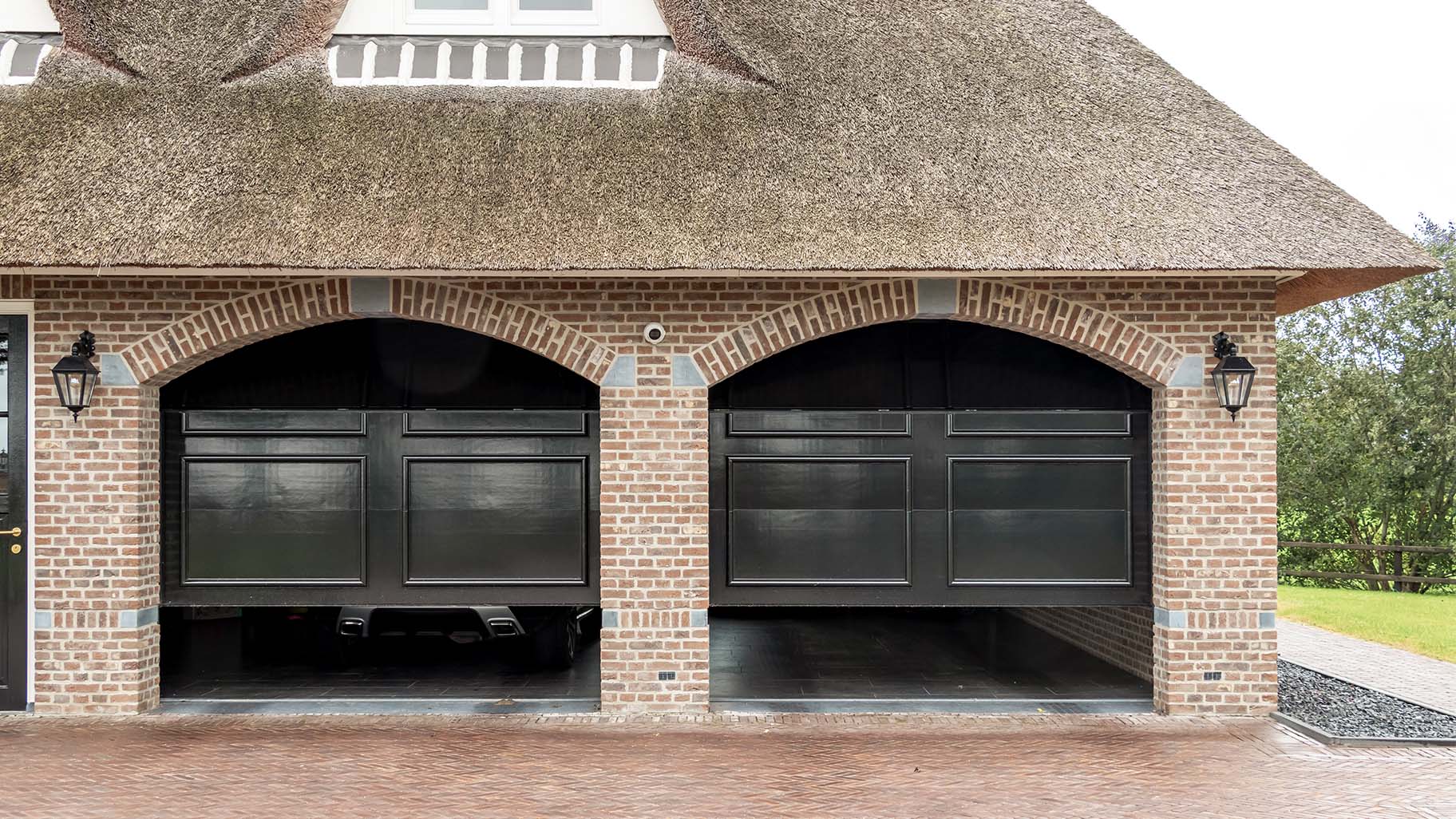 Landelijke woning met twee houten garagedeuren in klassieke stijl