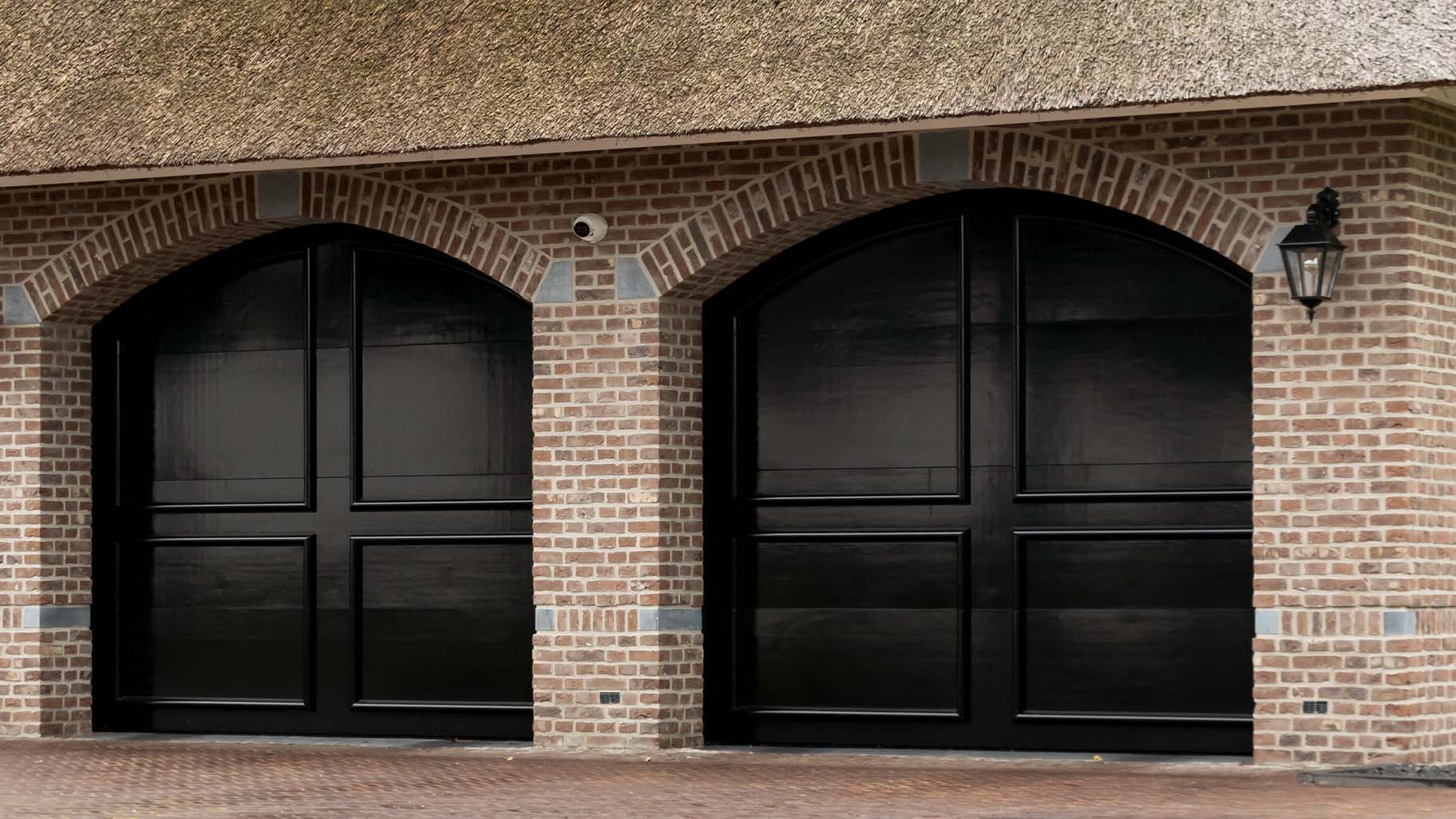 Landelijke woning met twee houten garagedeuren in klassieke stijl