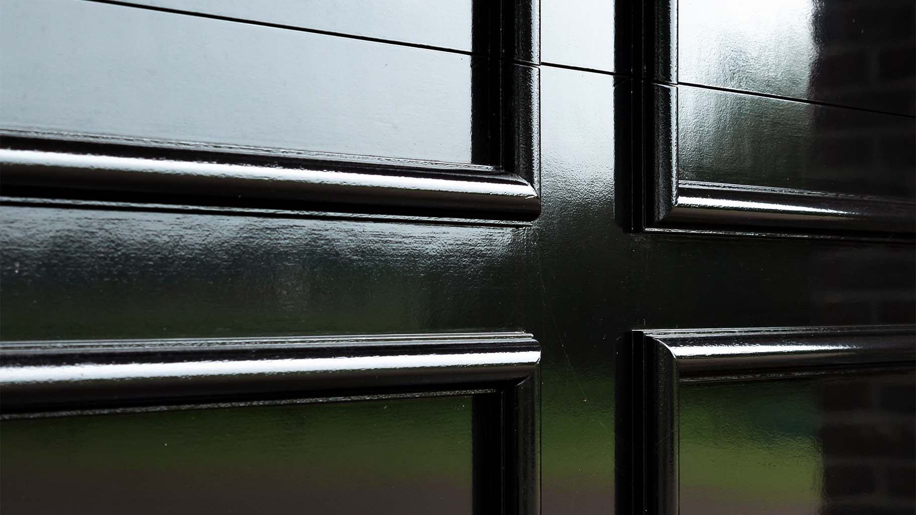 Detail van een houten garagedeur met een klassiek ontwerp