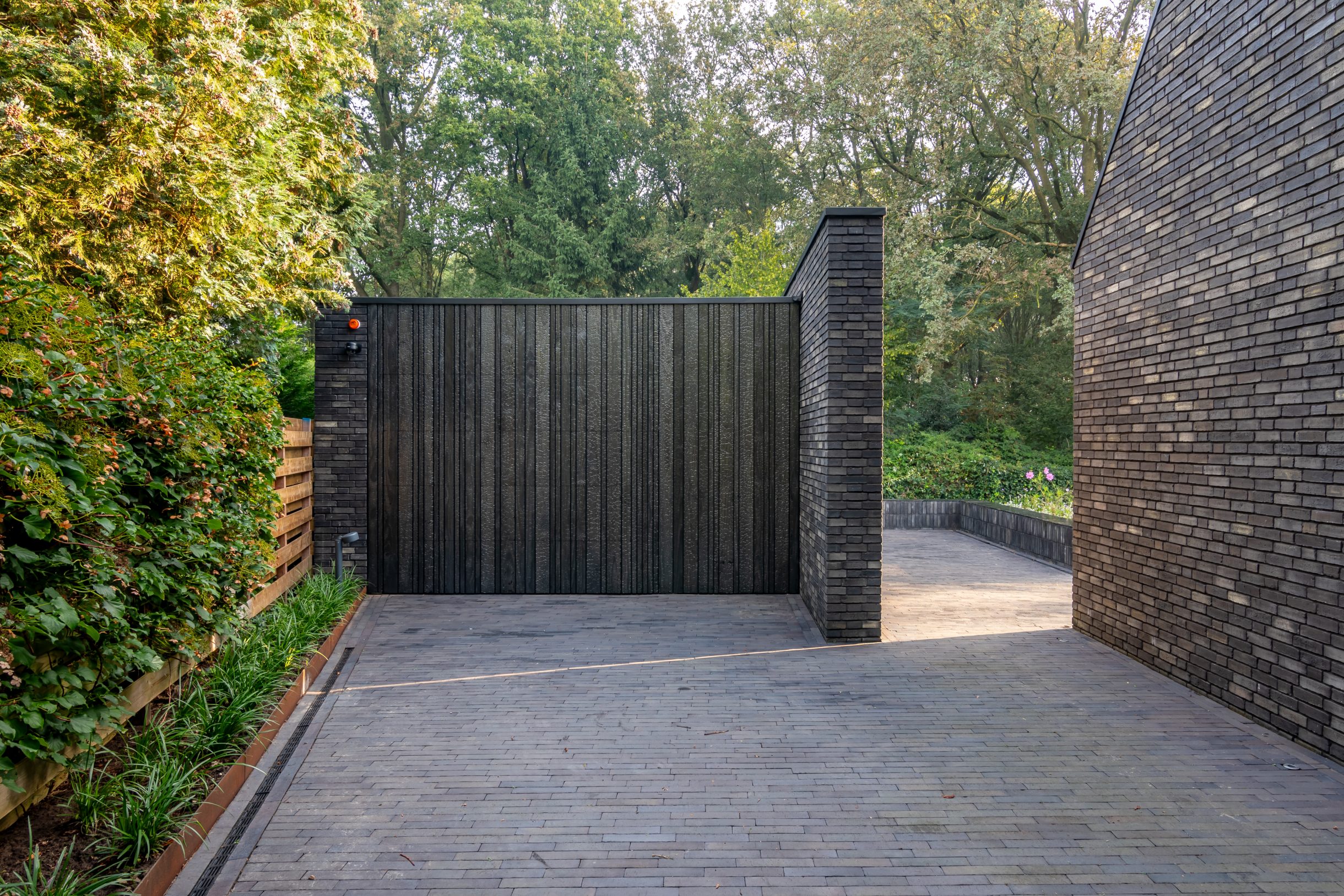 Different Doors Shou Sugi Ban garagedeur volledig verdwenen in moderne gevel