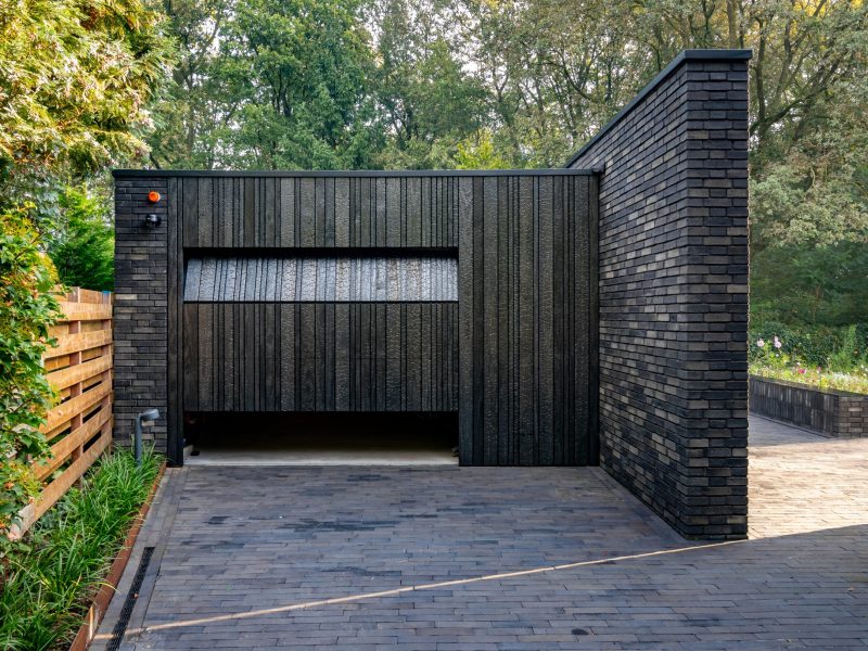 Shou Sugi Ban garagedeur verborgen in de gevel voor een strakke uitstraling