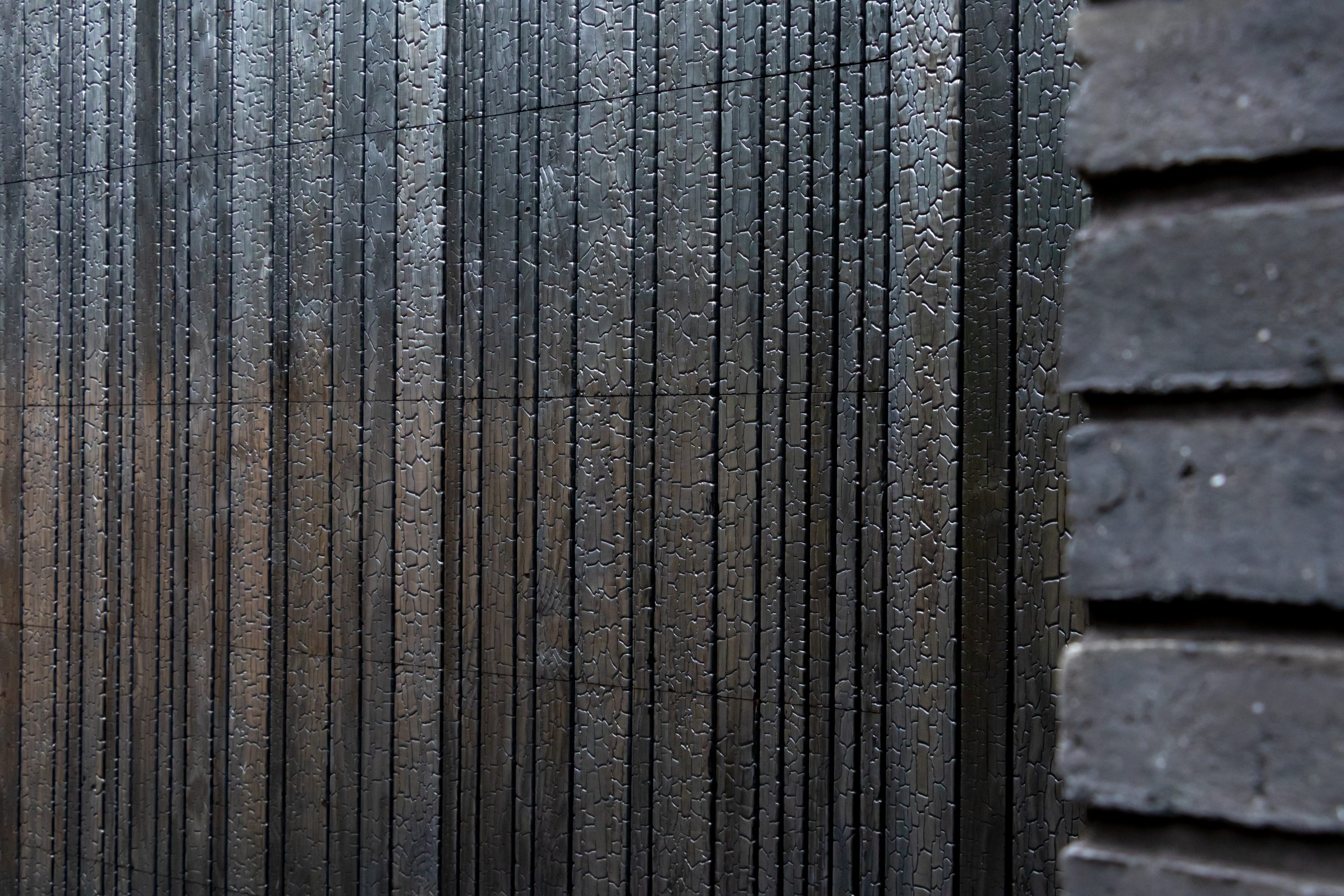 Detail van houten garagedeur van Shou Sugi Ban hout, met diep donkere en zwarte nerven