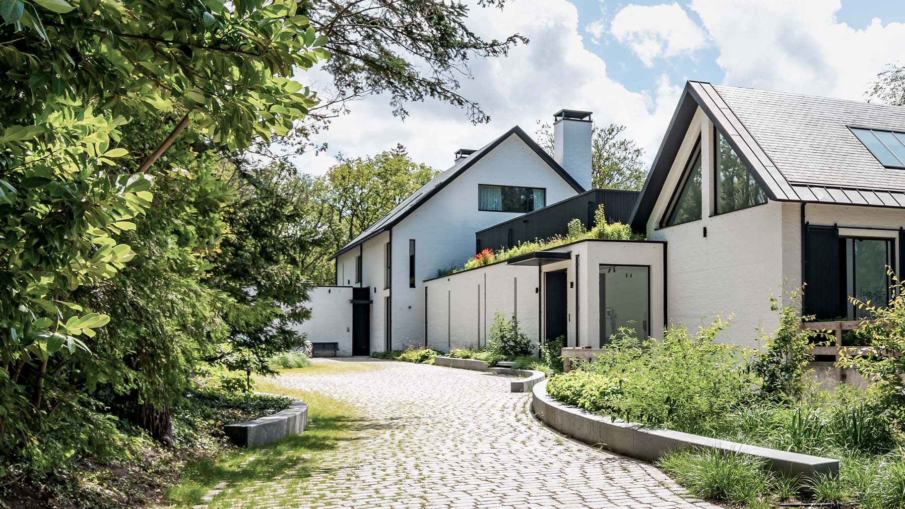 Pivoterende houten taatsdeur en garagedeur in dezelfde stijl different doors