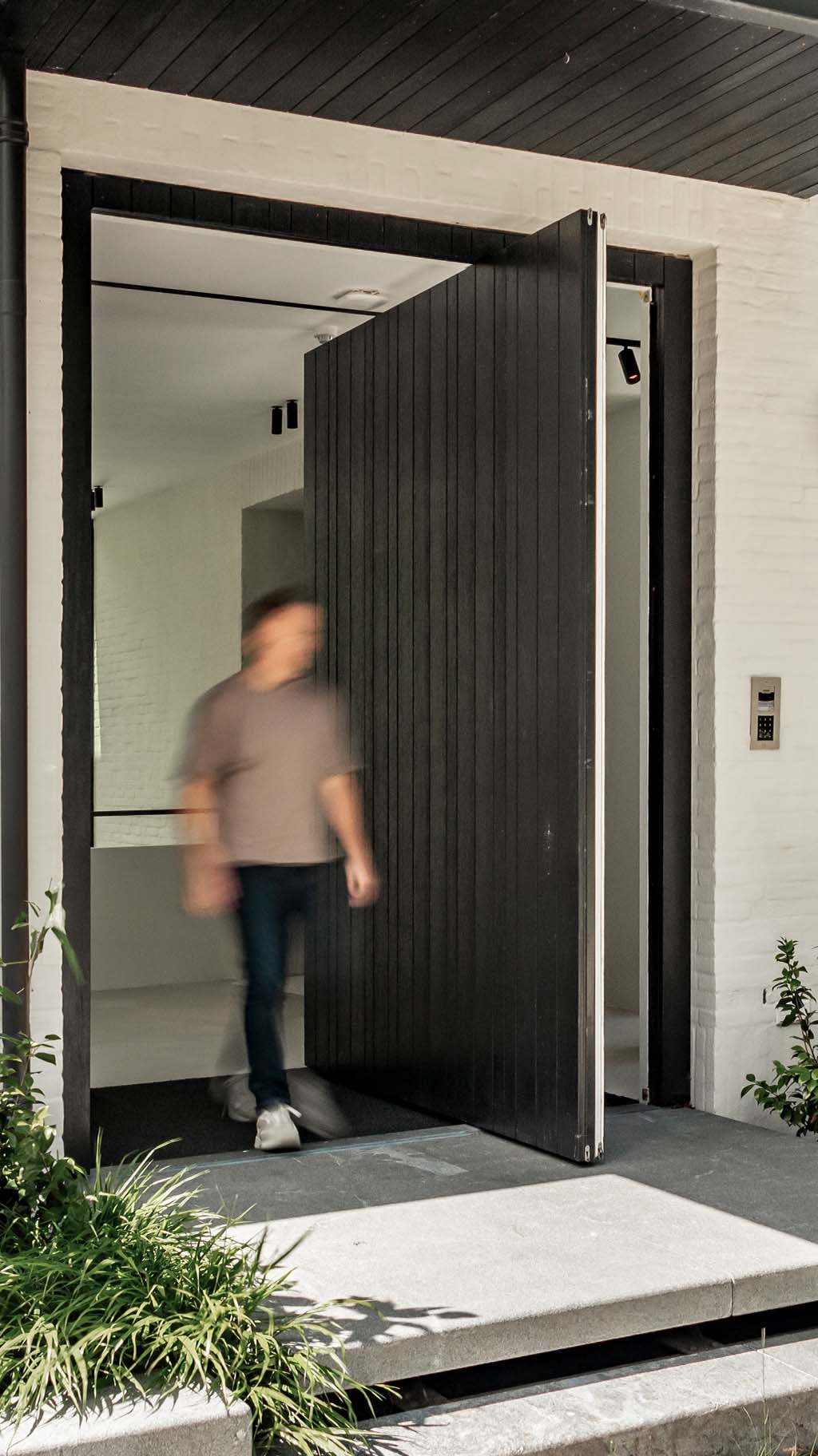 Pivoterende houten taatsdeur en garagedeur in dezelfde stijl different doors