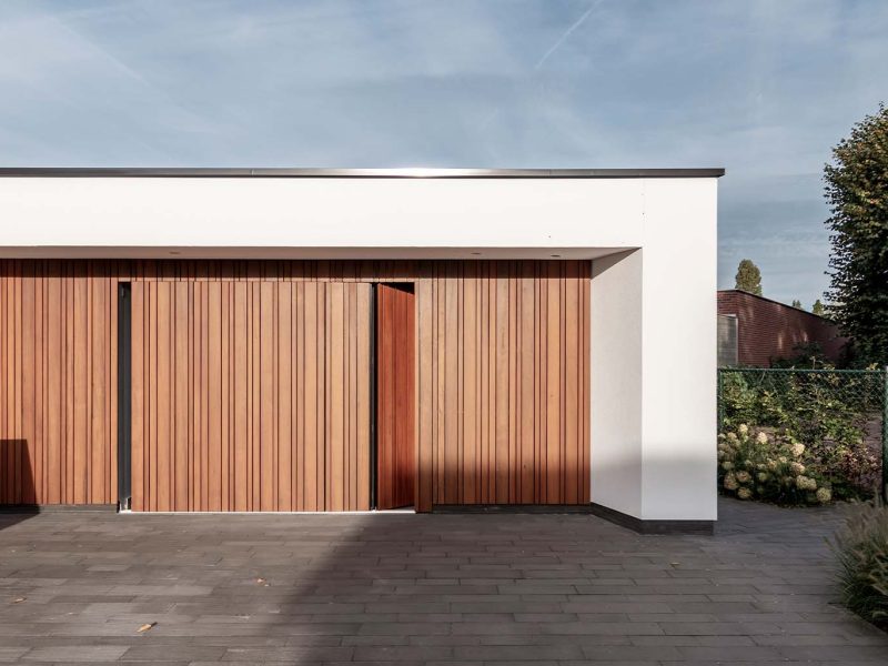 Moderne woning met zijwaartse fraké houten garagedeur