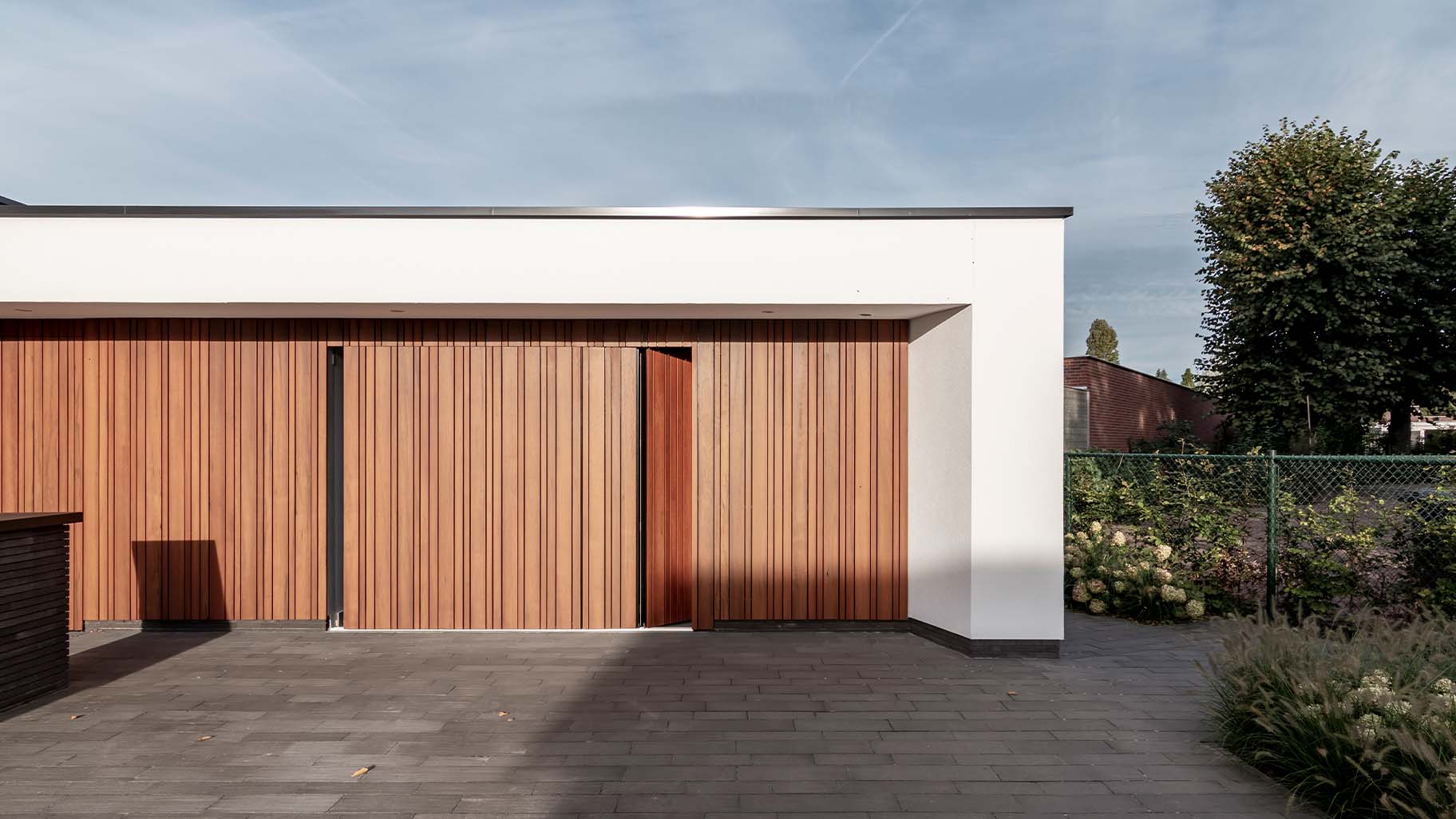Moderne woning met zijwaartse fraké houten garagedeur