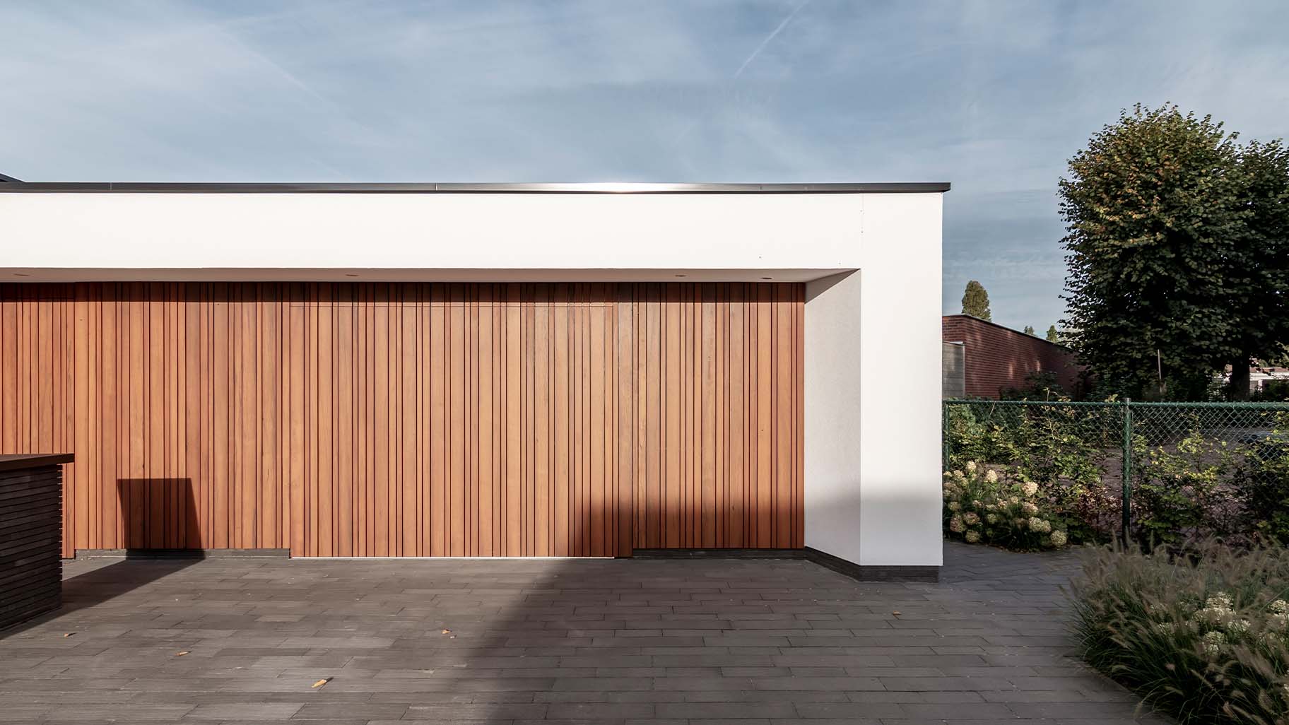Moderne woning met zijwaartse fraké houten garagedeur