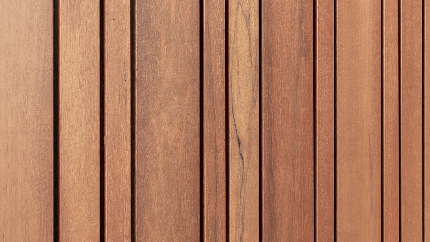 Detail van fraké houten garagedeur met zes perfect uitgelijnde secties en zichtbare houtnerf