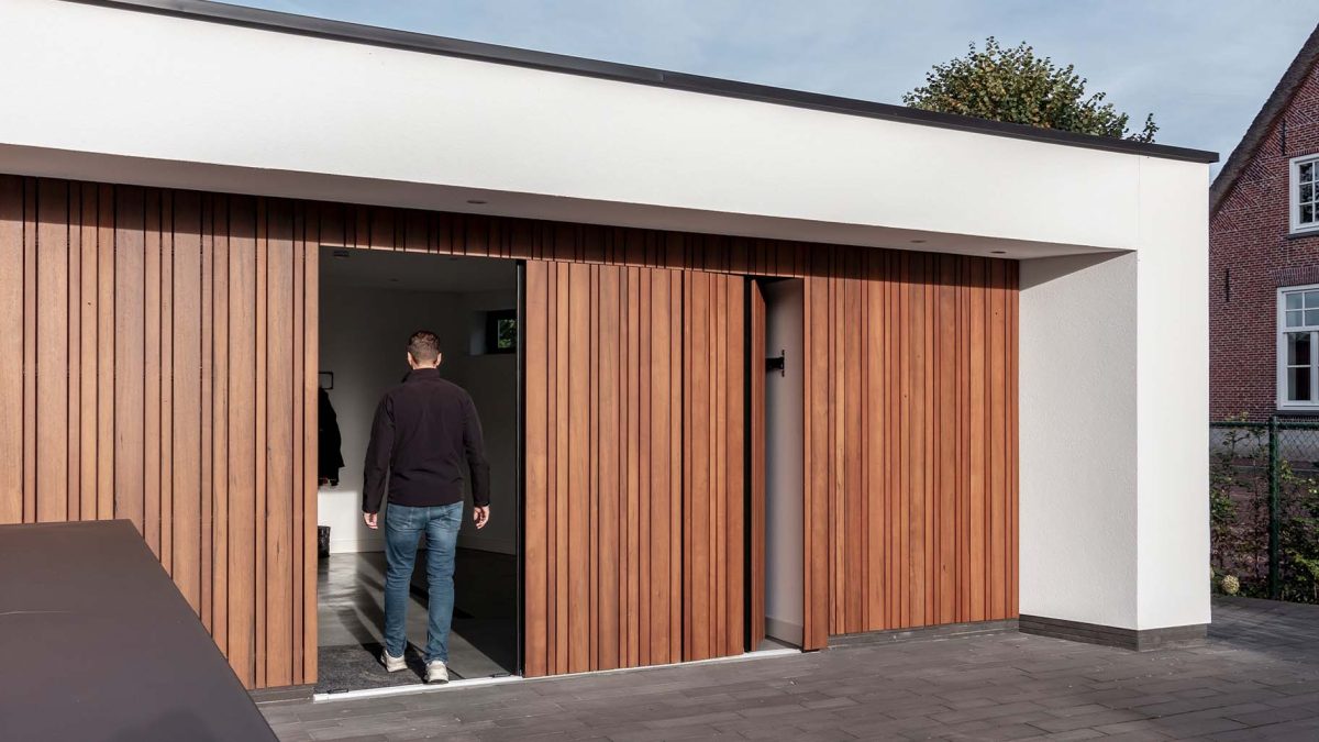 Different Doors zijwaartse garagedeur van fraké hout, naadloos geïntegreerd in moderne woning