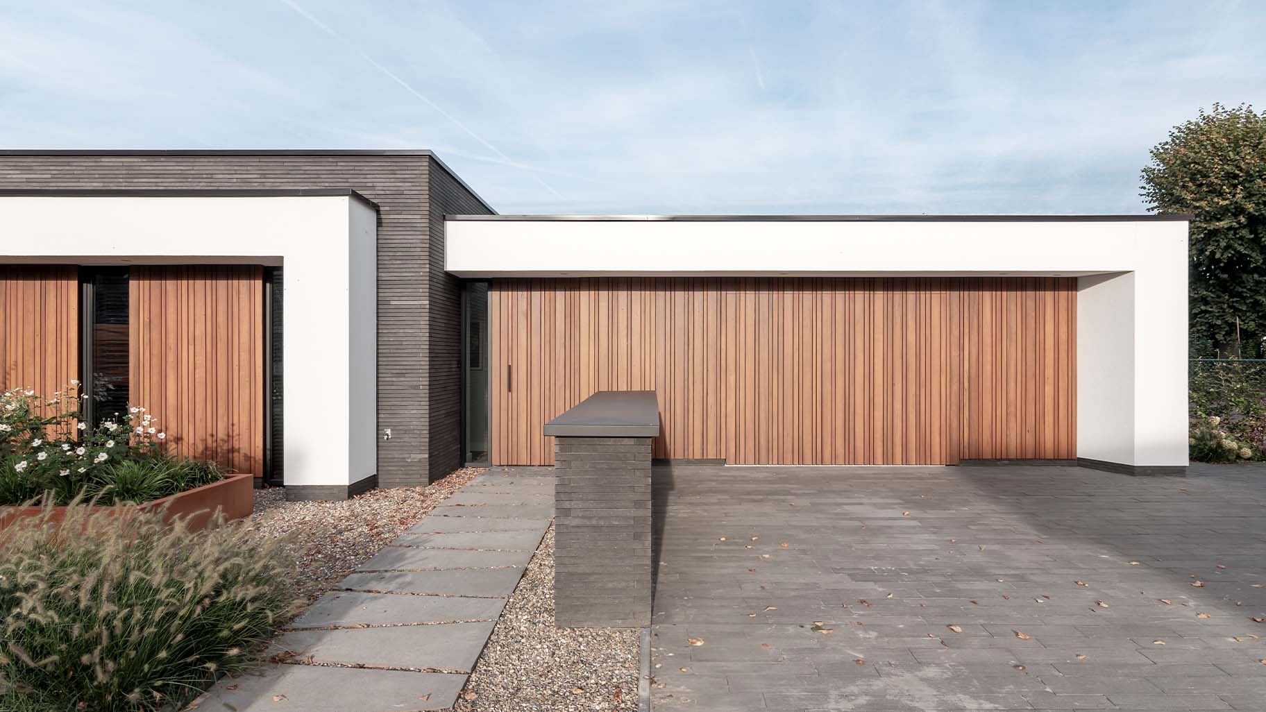 Moderne woning met zijwaartse fraké houten garagedeur
