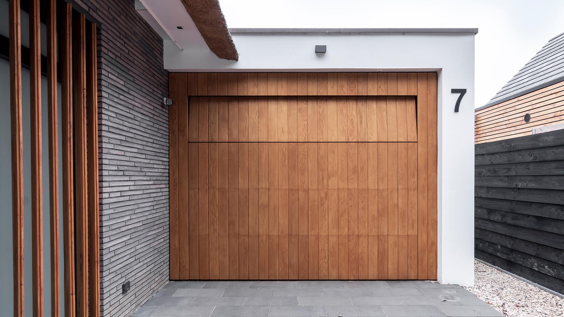 Garagedeur van eikenhout verwerkt in het exterieur van een villa