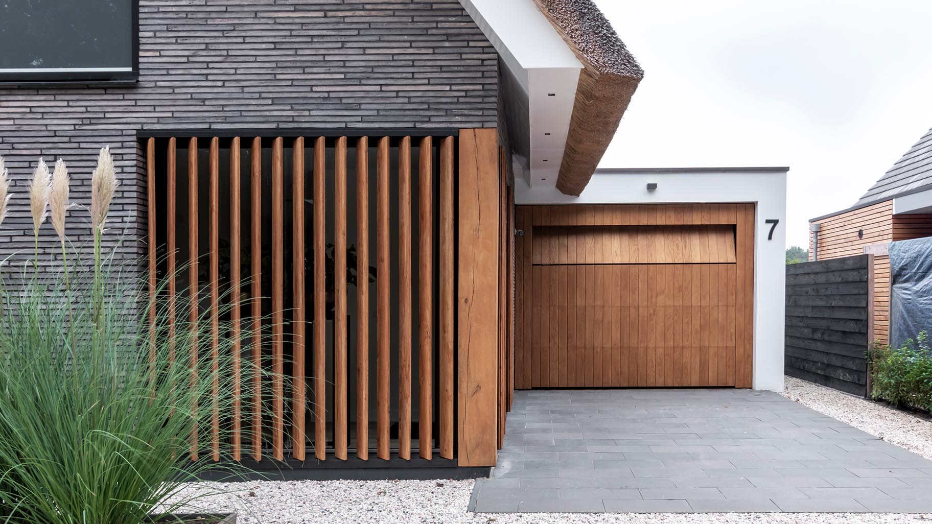 Garagedeur van eikenhout verwerkt in het exterieur van een villa