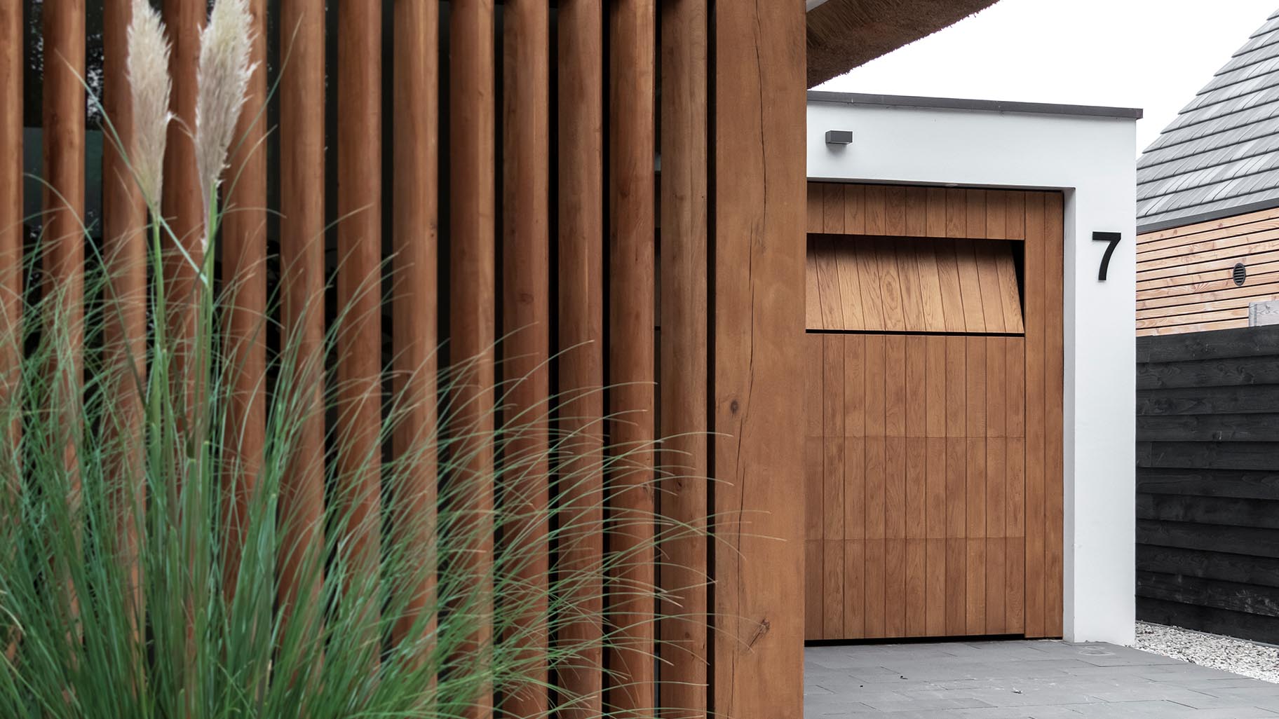 Garagedeur van eikenhout verwerkt in het exterieur van een villa