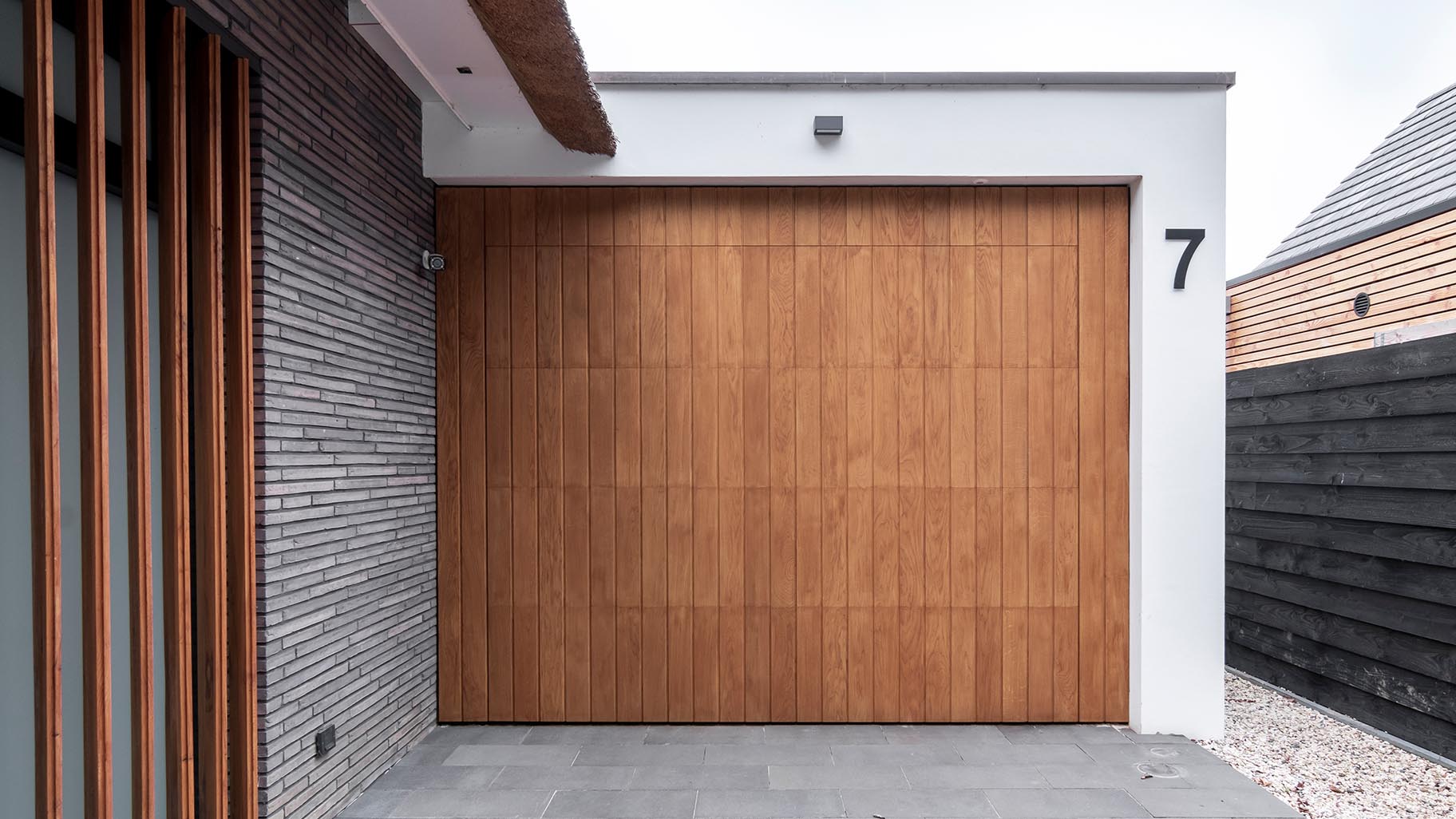Garagedeur van eikenhout verwerkt in het exterieur van een villa