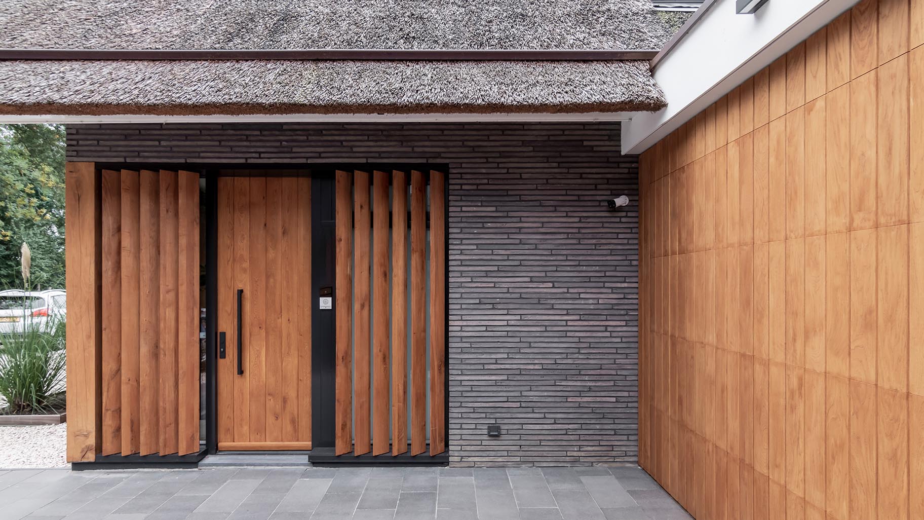 Garagedeur van eikenhout verwerkt in het exterieur van een villa