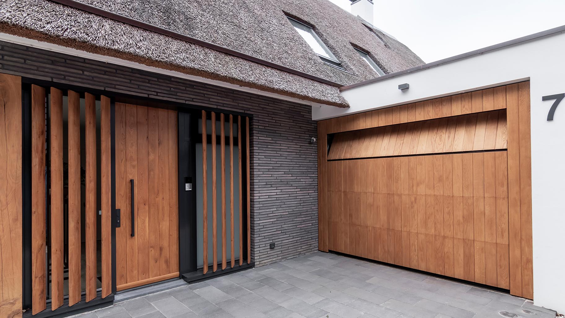 Garagedeur van eikenhout verwerkt in het exterieur van een villa