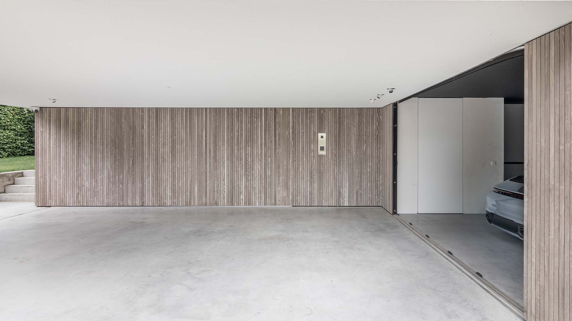 Moderne woning in Boxtel met twee zijwaartse houten garagedeuren met loopdeur