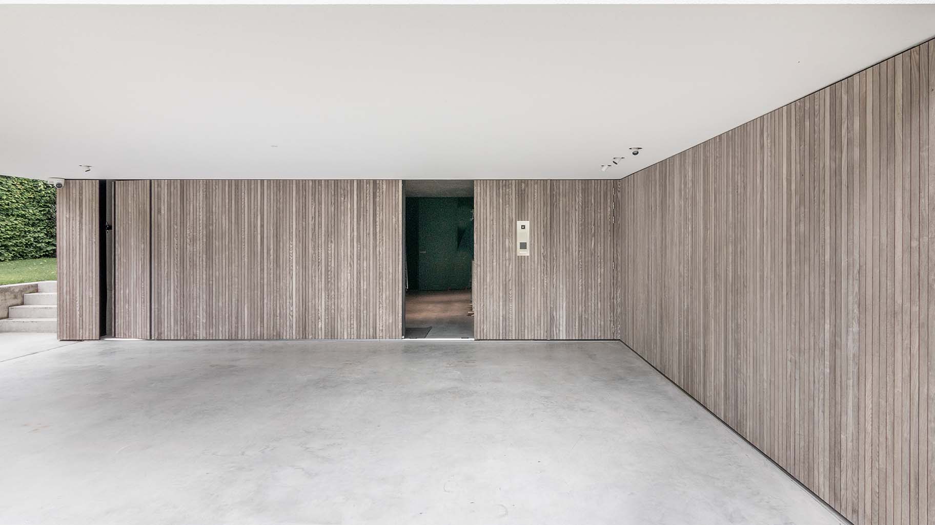 Moderne woning in Boxtel met twee zijwaartse houten garagedeuren met loopdeur