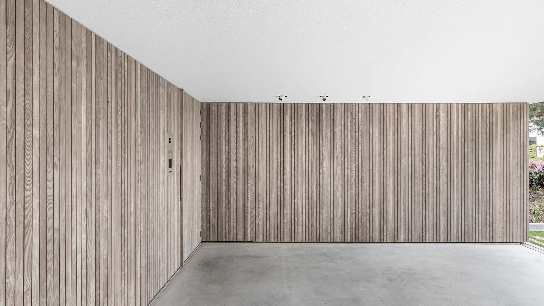 Moderne woning in Boxtel met twee zijwaartse houten garagedeuren met loopdeur