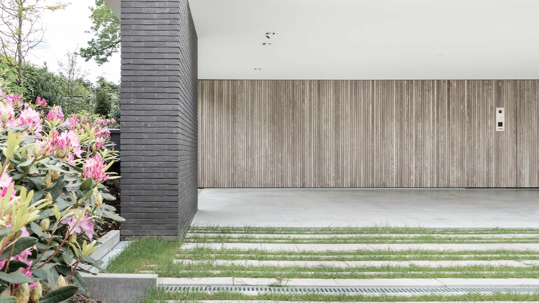 Verticale houten latten in de gevel met garagedeuren