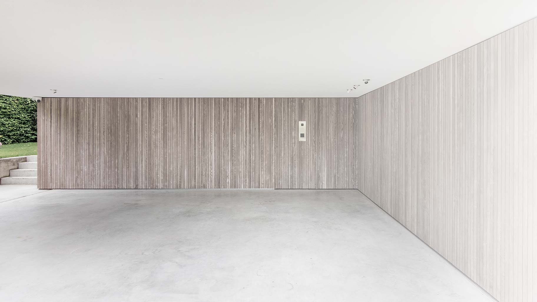 Verticale houten latten in de gevel met garagedeuren