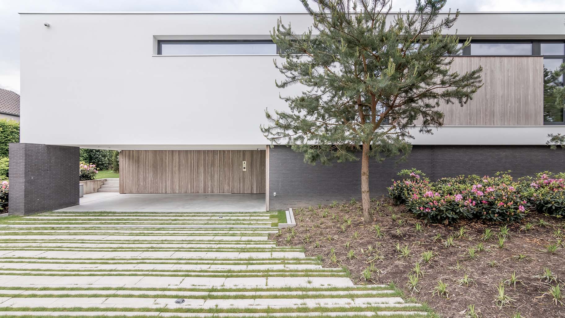Moderne woning in Boxtel met twee zijwaartse houten garagedeuren met loopdeur