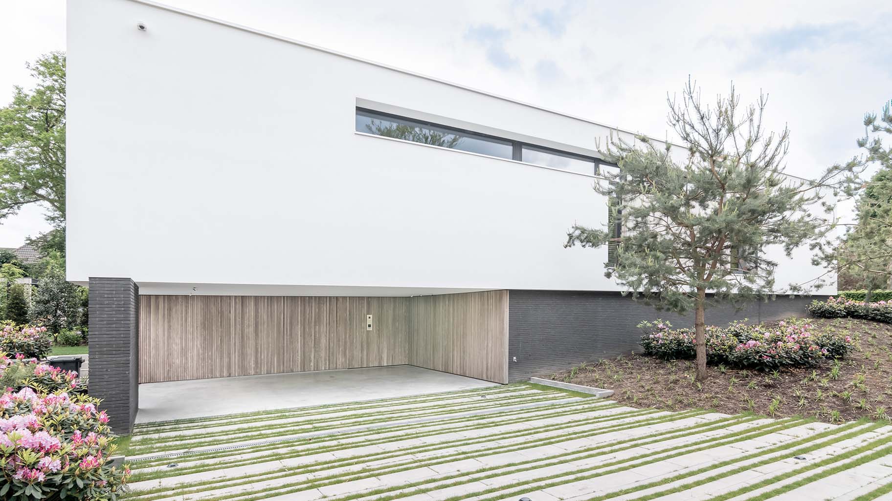 Moderne woning in Boxtel met twee zijwaartse houten garagedeuren met loopdeur