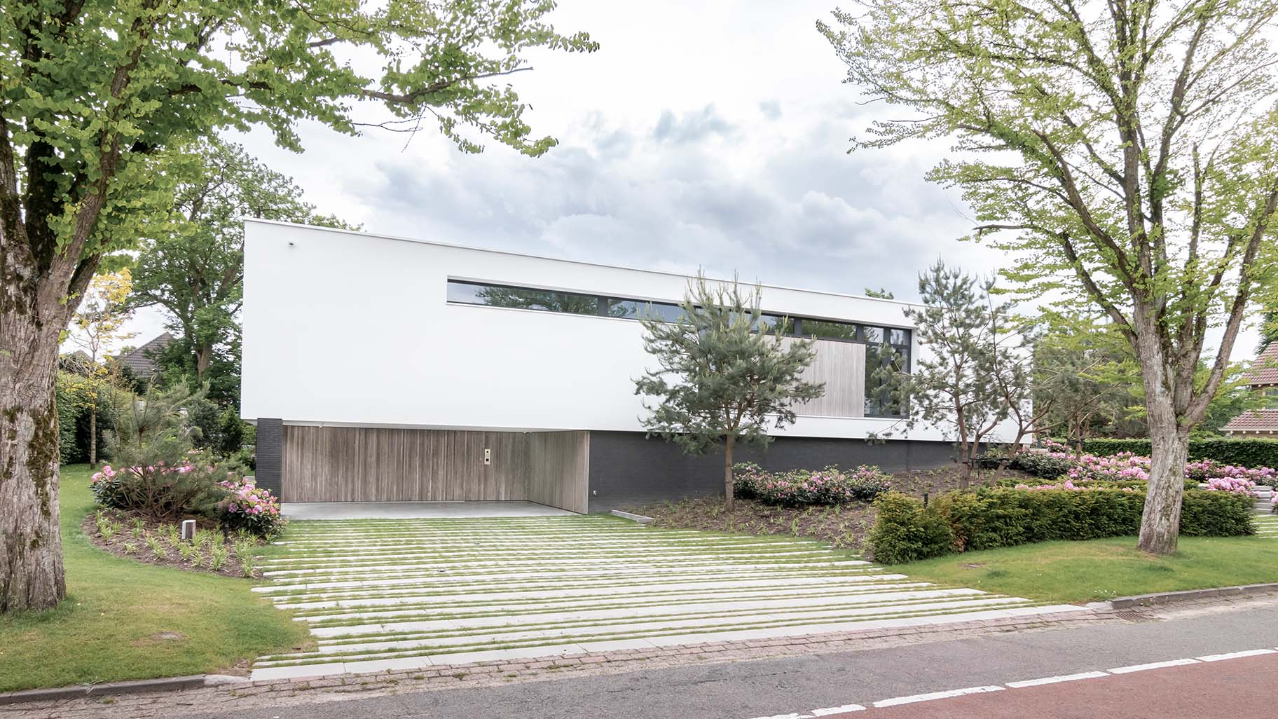 Moderne woning in Boxtel met twee zijwaartse houten garagedeuren met loopdeur