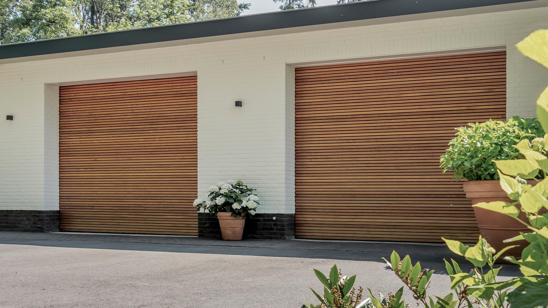 Horizontale houten sectionaaldeuren van Red Cedar bij wit gestucte woning