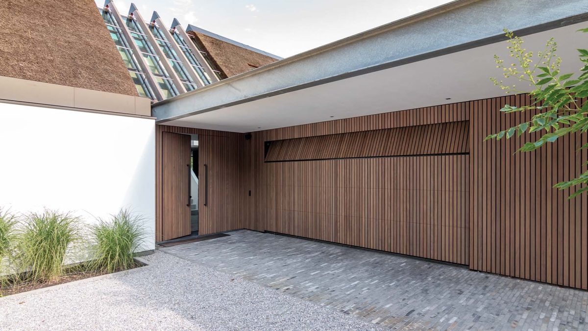 Afrormosia houten garagedeur 5 meter breed geïntegreerd in gevel