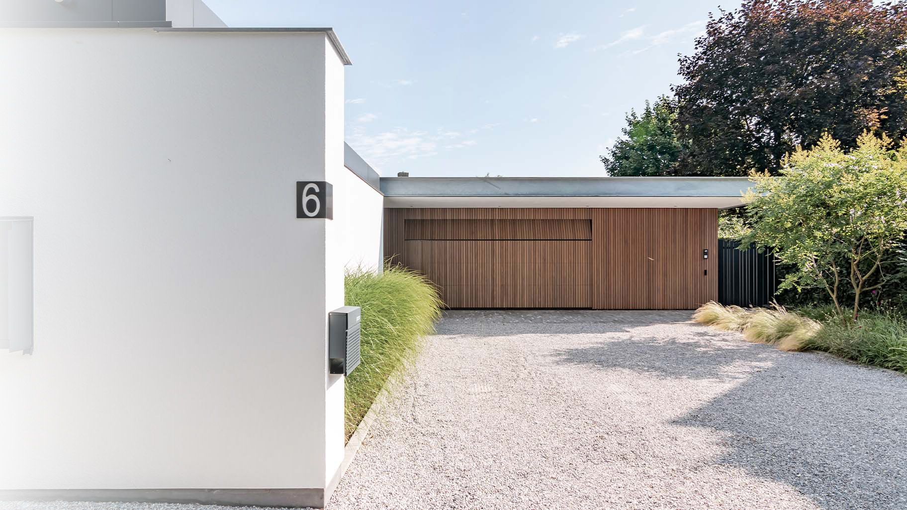 Afrormosia houten garagedeur 5 meter breed geïntegreerd in gevel