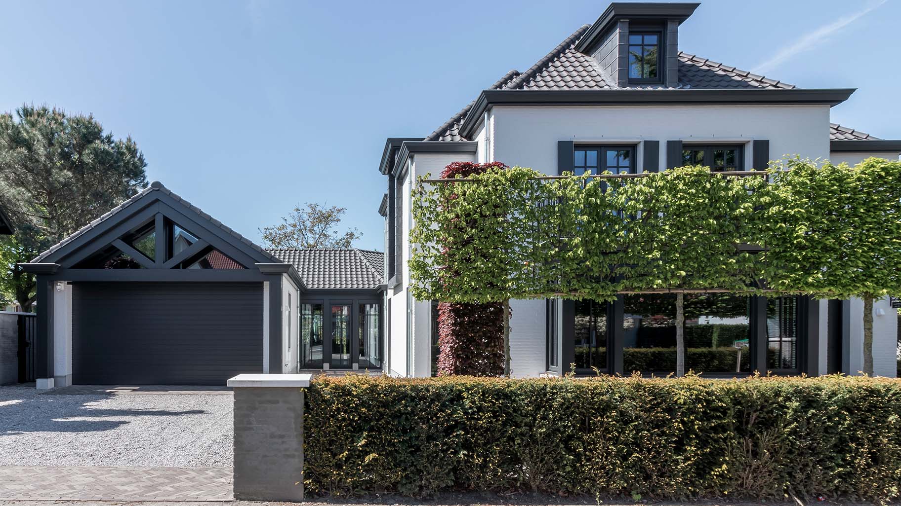 6 meter brede houten sectionaaldeur, uitgevoerd in Red Cedar en achter de dag geplaatst