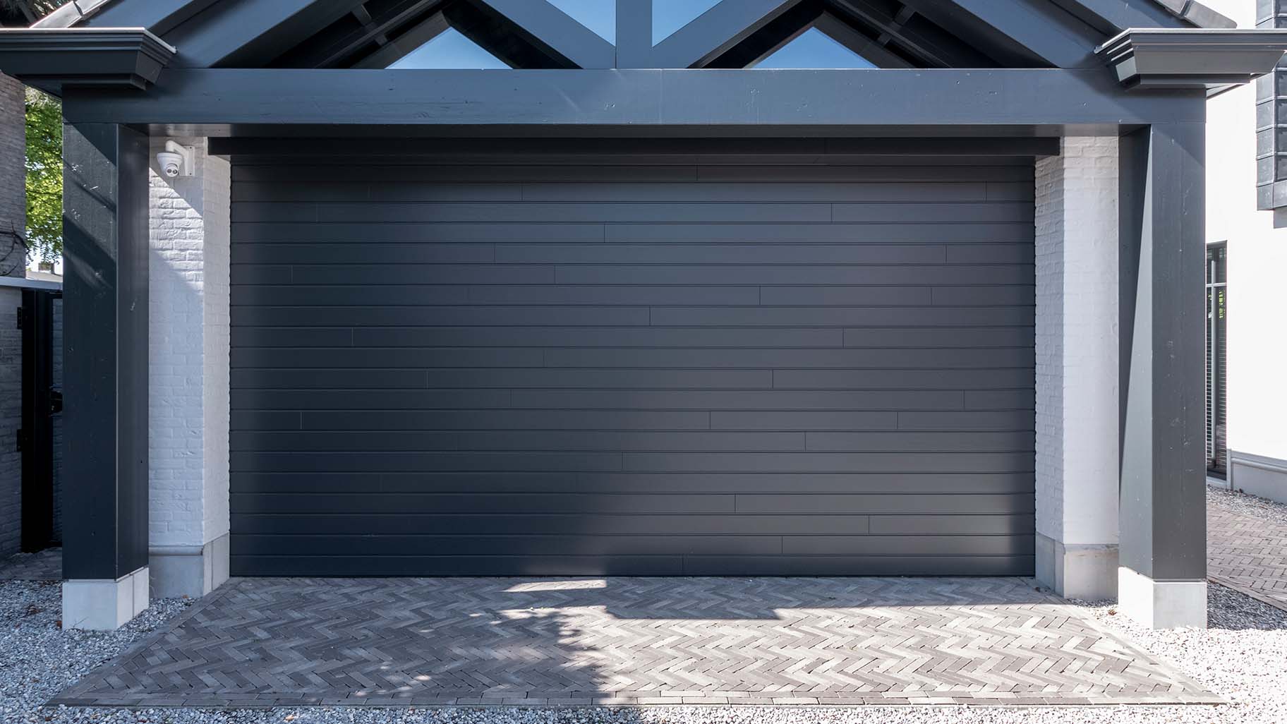 6 meter brede houten sectionaaldeur, uitgevoerd in Red Cedar en achter de dag geplaatst