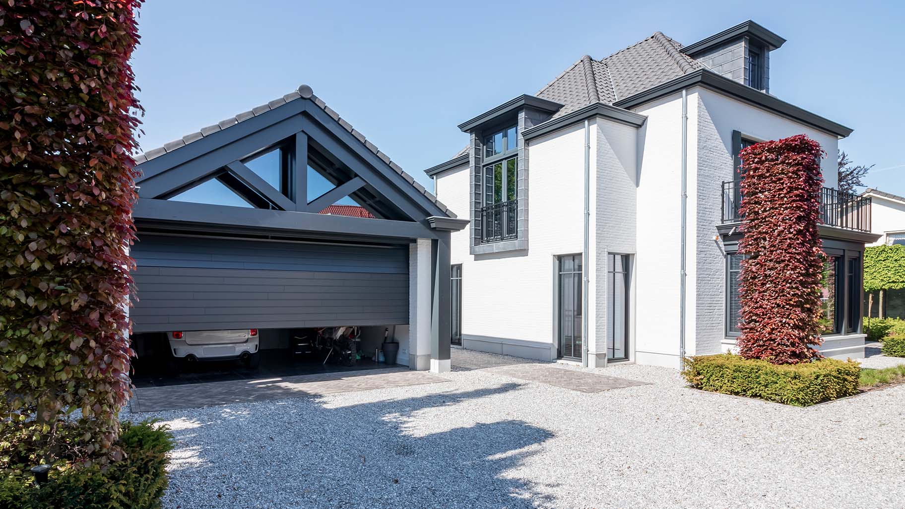 6 meter brede houten sectionaaldeur, uitgevoerd in Red Cedar en achter de dag geplaatst