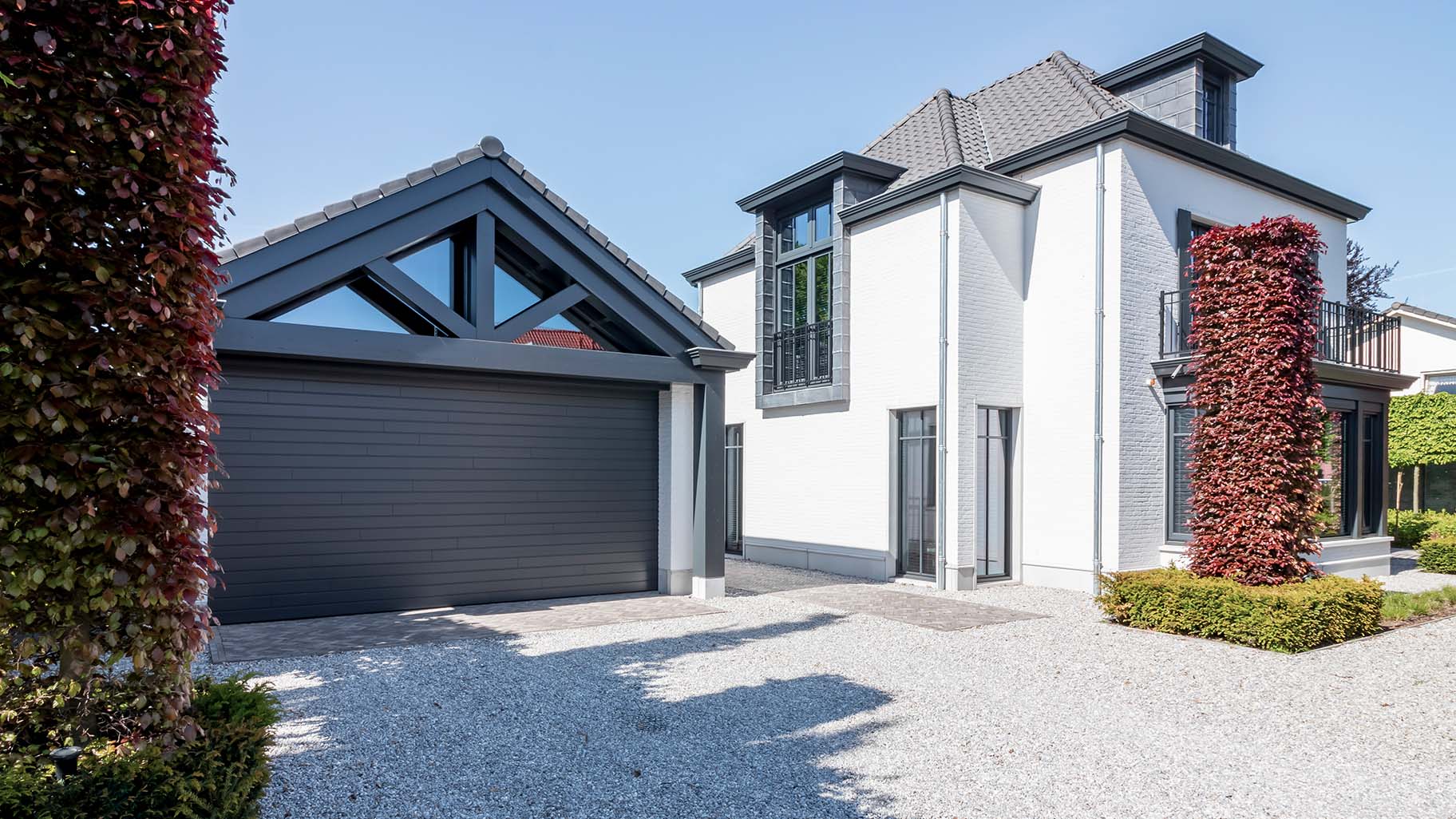 6 meter brede houten sectionaaldeur, uitgevoerd in Red Cedar en achter de dag geplaatst