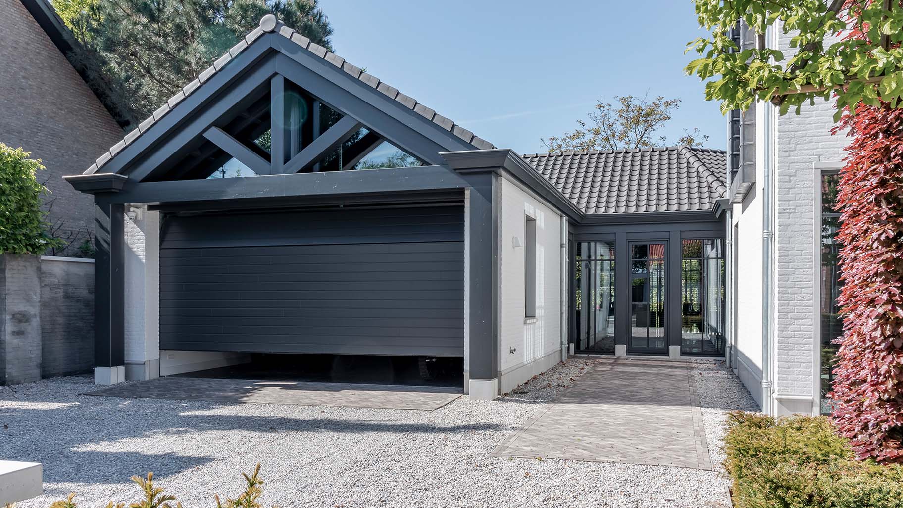 6 meter brede houten sectionaaldeur, uitgevoerd in Red Cedar en achter de dag geplaatst