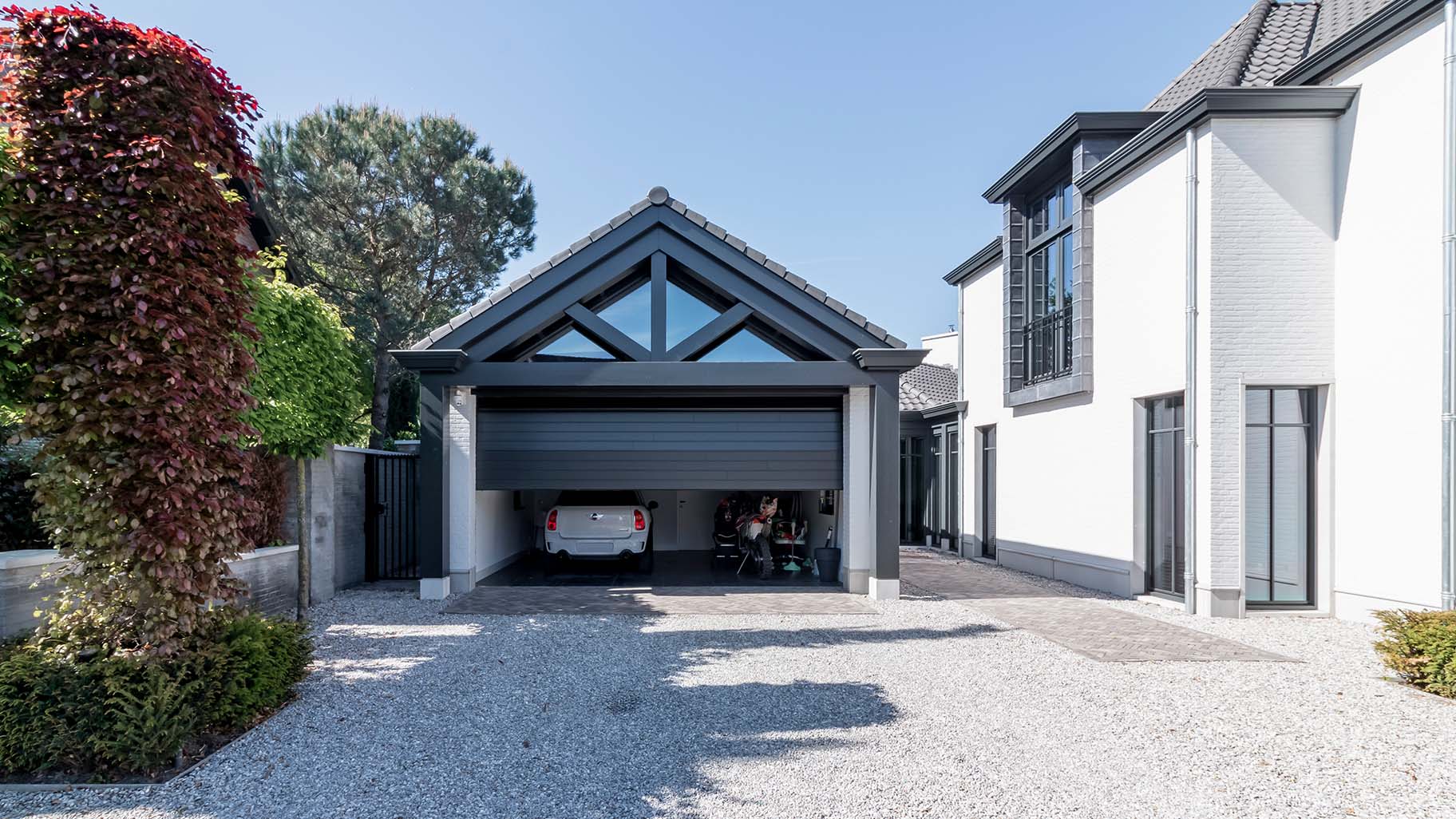 6 meter brede houten sectionaaldeur, uitgevoerd in Red Cedar en achter de dag geplaatst