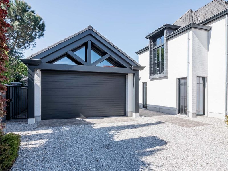 6 meter brede houten sectionaaldeur, uitgevoerd in Red Cedar en achter de dag geplaatst