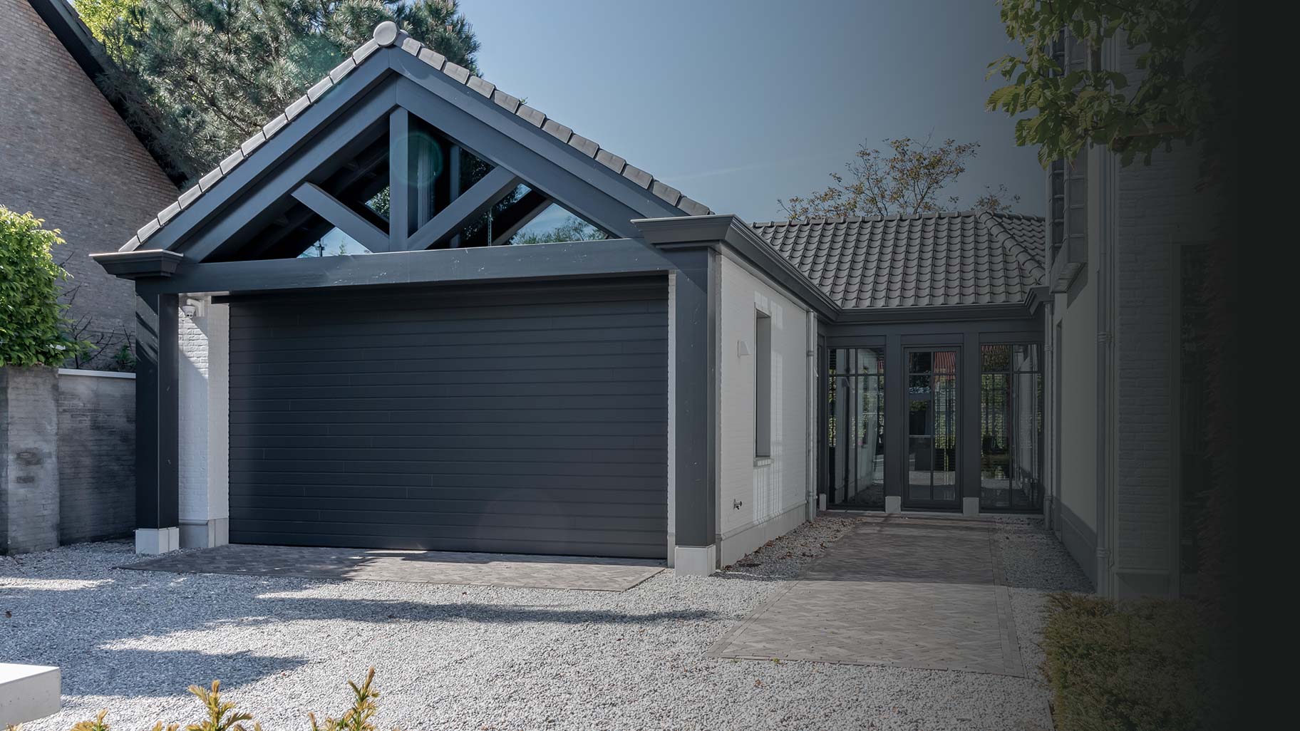 grijsblauw geschilderde garagedeur van Red Cedar is subtiel achter de gevel geplaatst