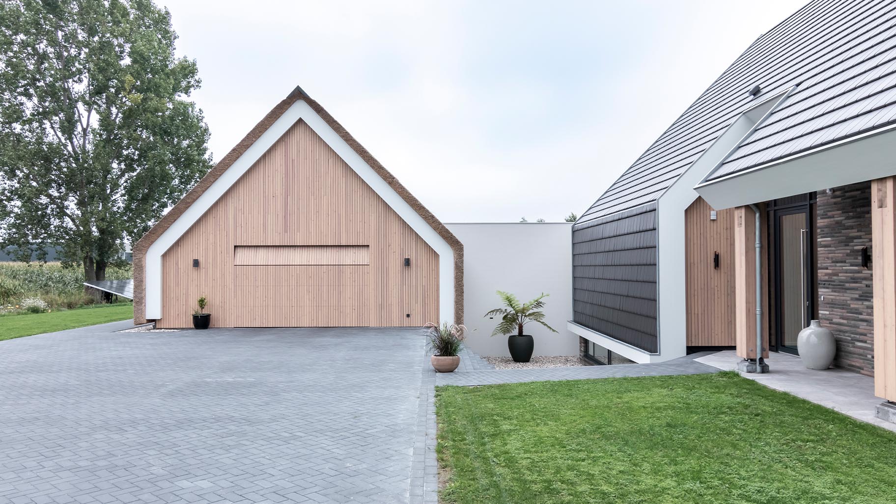 Schuurwoning met rieten dak en houten sectionaaldeur