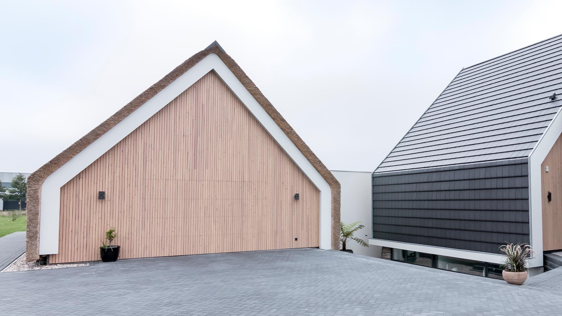Schuurwoning met rieten dak en houten sectionaaldeur