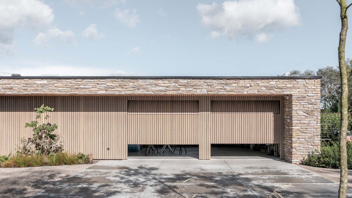 Moderne nieuwbouwwoning met twee houten sectionaaldeuren van Afrormosia hout