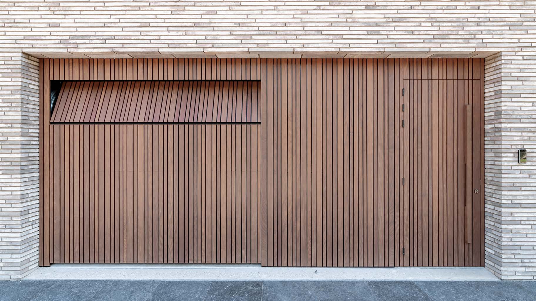 Houten garagedeuren met loopdeur, handig verwerkt in de voorgevel