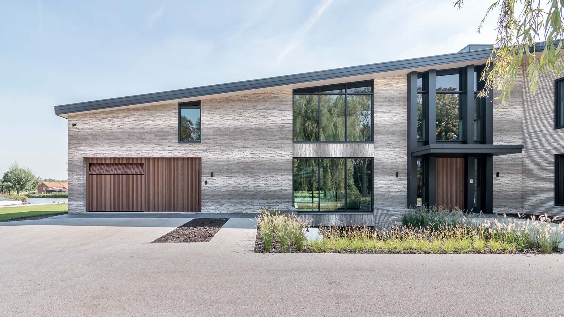 Houten taatsdeur en garagedeur geïntegreerd in de gevel